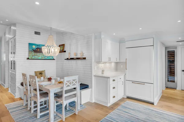a kitchen with a white cabinets and chairs