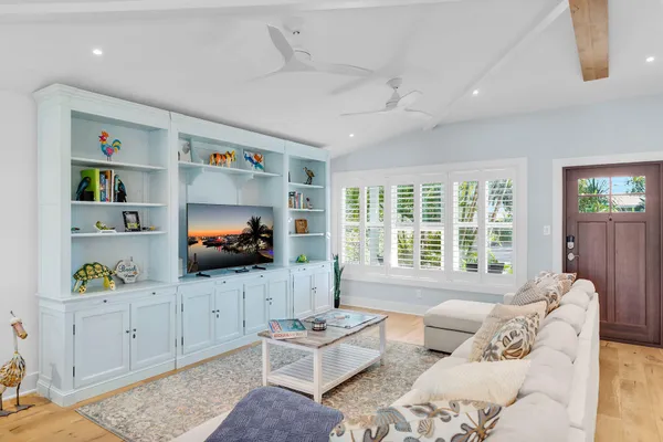 a living room with furniture a flat screen tv and a window