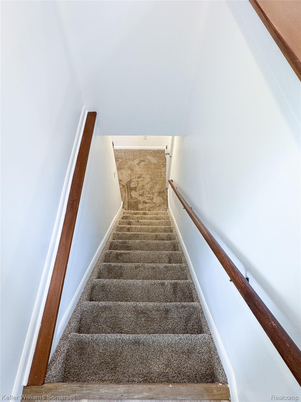 1821 Nazareth Road Kalamazoo, MI 49048 - Photo 13 of 20 Carpeted staircase featuring white walls and dual wood handrails