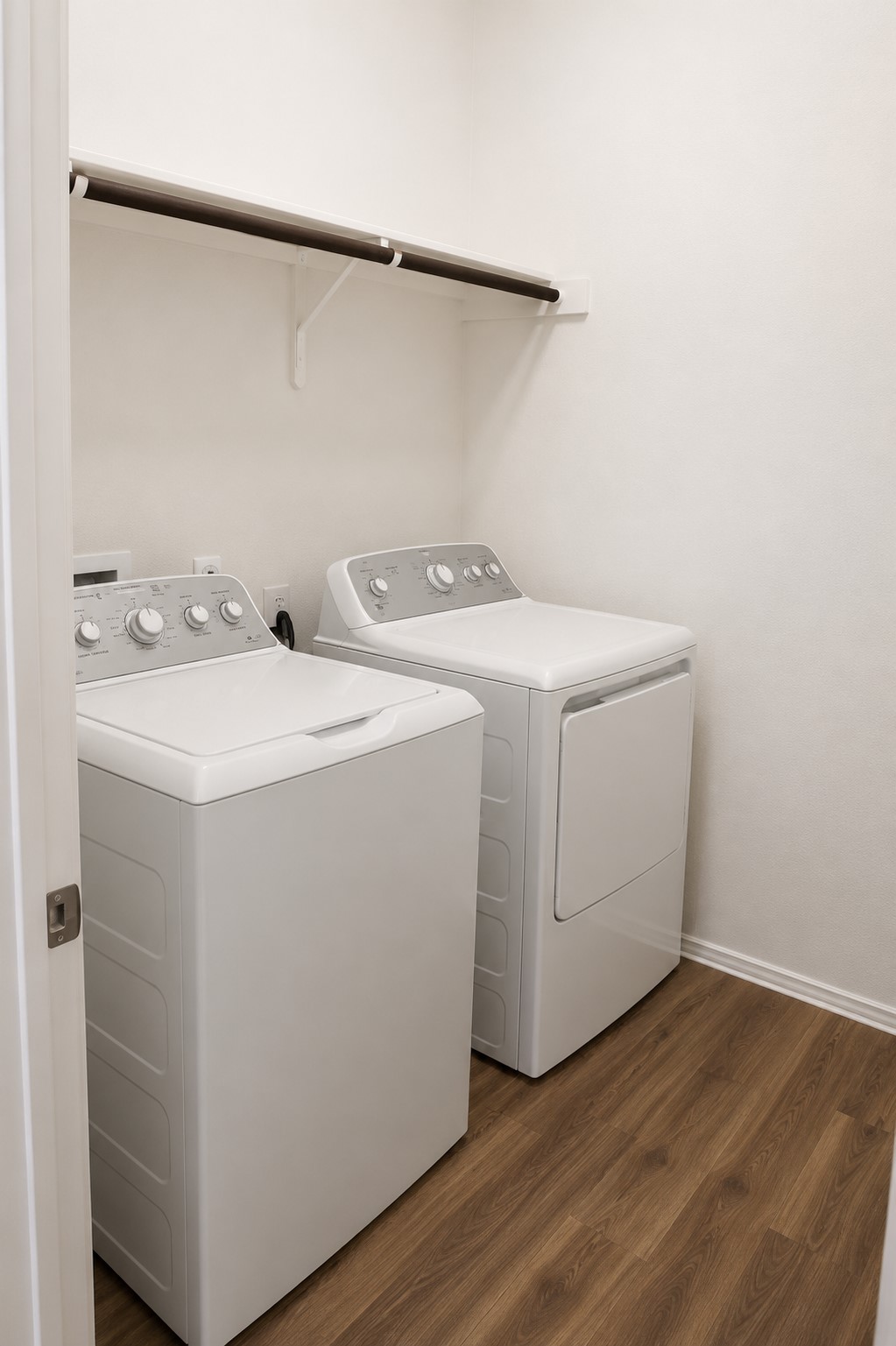 828 Mallow Road Leander, TX 78641 - Photo 12 of 14 A dedicated laundry space boasts wood flooring and ample shelving, simplifying household chores.