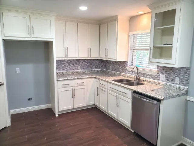 a kitchen with a sink cabinets appliances and a window