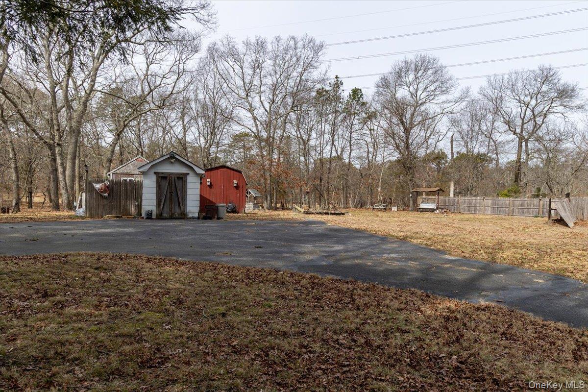 309 Primrose Path Manorville, NY 11949 - Photo 8 of 26 a view of road with large trees