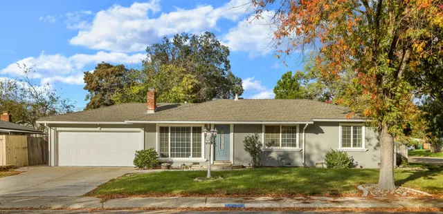 a front view of a house with a yard and potted plants