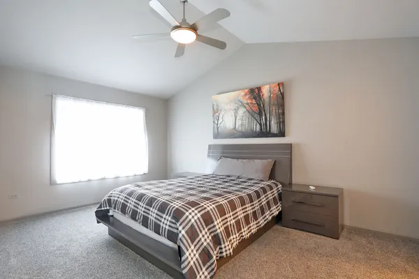 a bedroom with a large bed and a chandelier