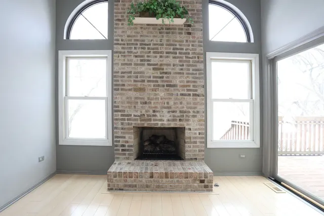 a view of an empty room with a fireplace and a window