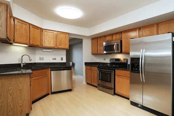 a kitchen with stainless steel appliances granite countertop a stove a sink and a microwave