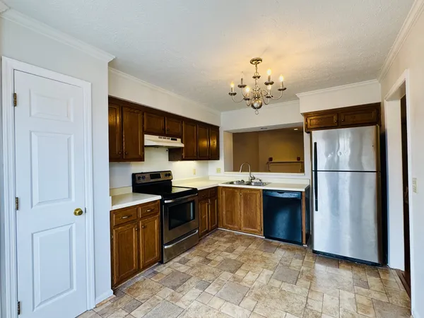 a kitchen with stainless steel appliances granite countertop a refrigerator a stove top oven a sink and dishwasher