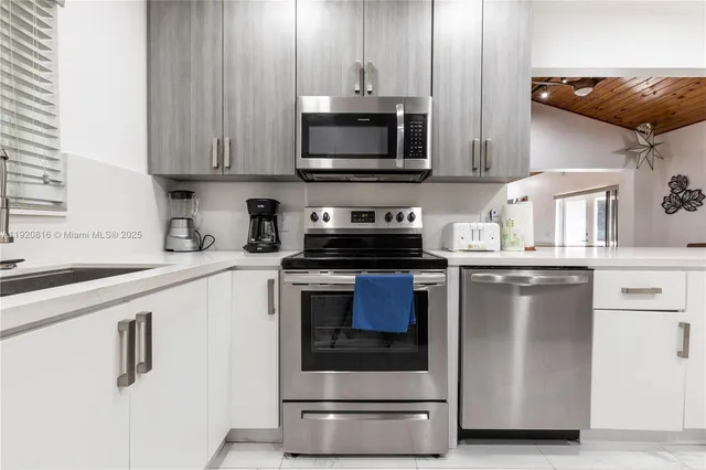 a bedroom with a bed and a flat tv screen on dresser