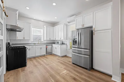 a kitchen with a refrigerator a sink and a stove top oven