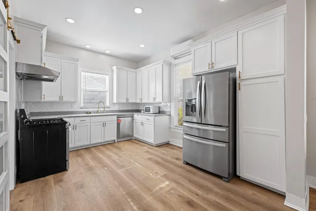 a kitchen with a refrigerator a sink and a stove top oven