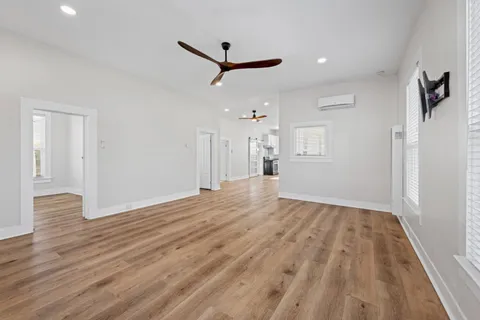 a view of empty room with wooden floor and ceiling fan