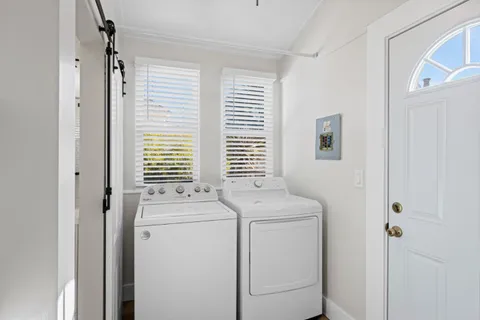 a view of washer and dryer with bathroom in the background