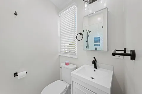 a bathroom with a sink a toilet and a mirror