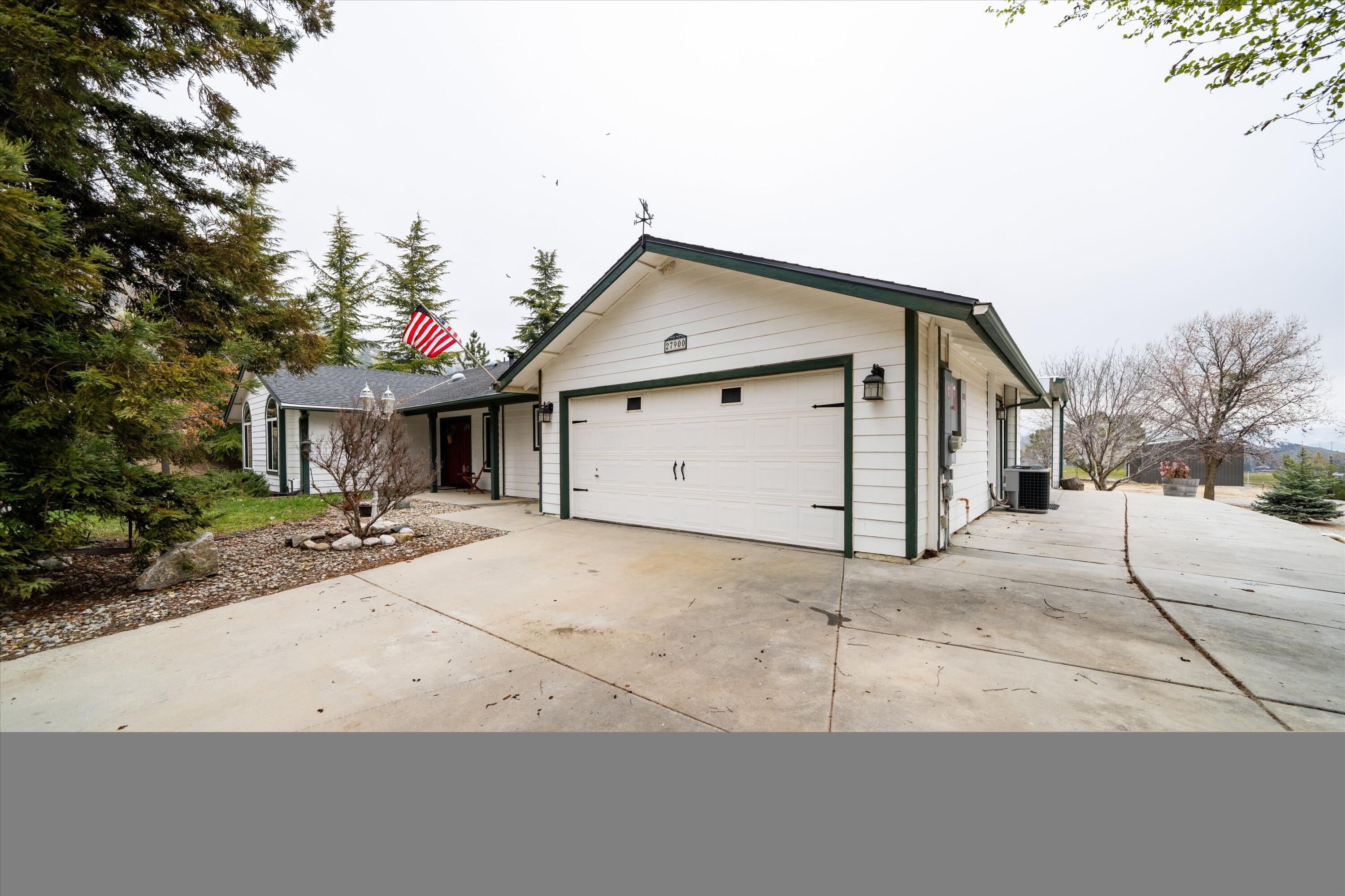 27900 Cummings Valley Road Tehachapi, CA 93561 - Photo 2 of 23 a front view of a house with a yard and garage