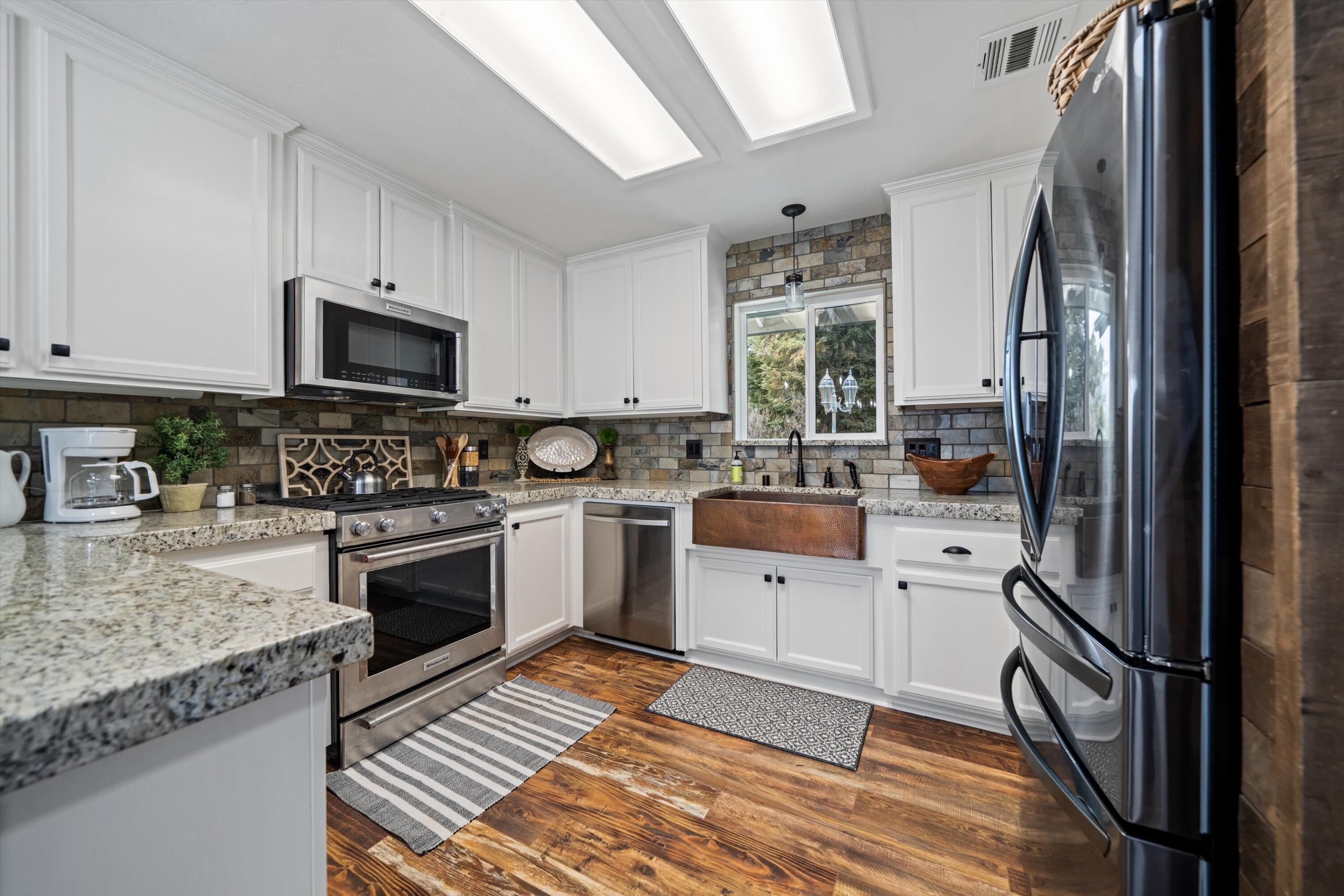 27900 Cummings Valley Road Tehachapi, CA 93561 - Photo 6 of 23 a kitchen with stainless steel appliances granite countertop a stove a sink and a refrigerator