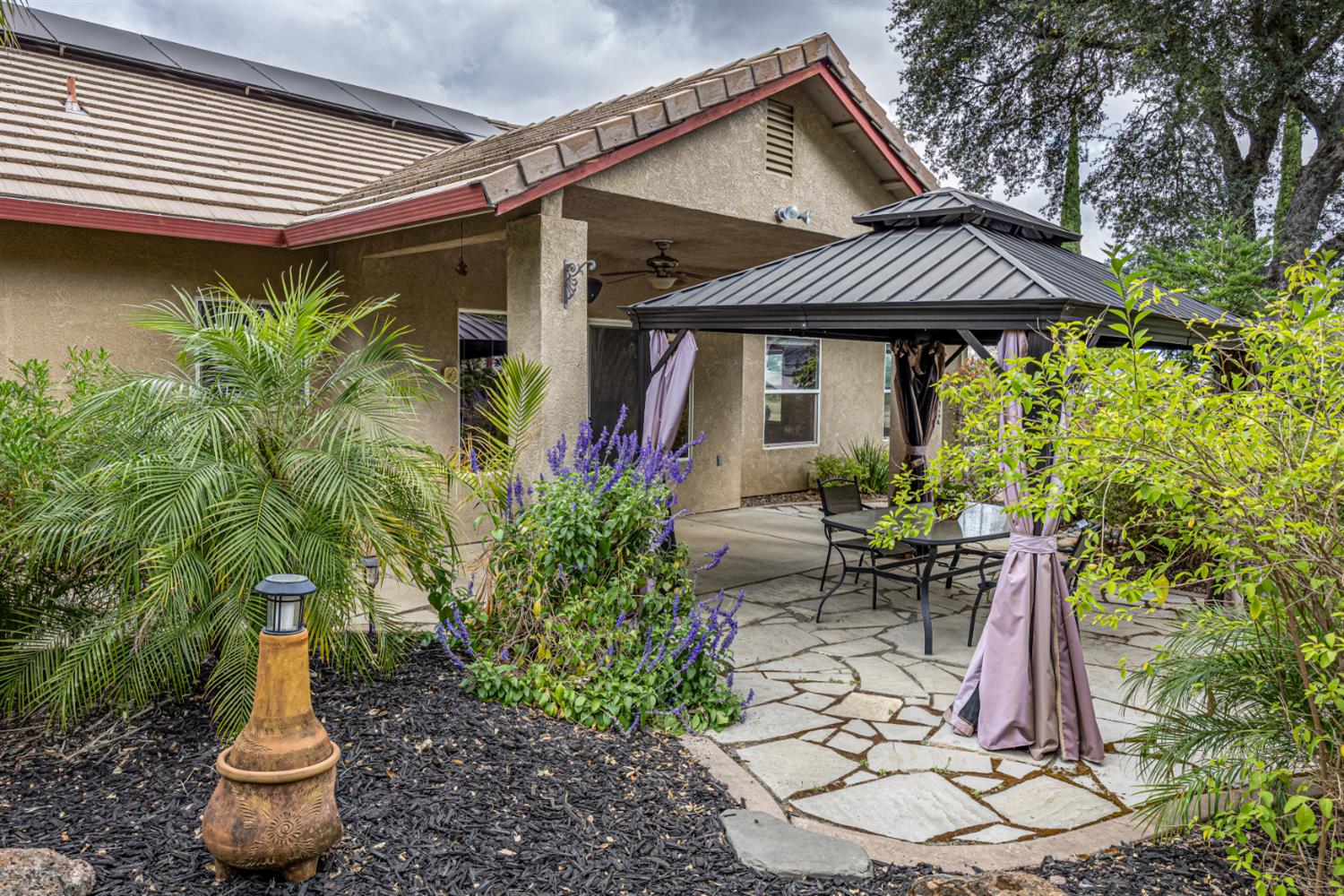 2083 State Rte 26 Valley Springs, CA 95252 - Photo 32 of 59 a patio with a table and chairs and potted plants