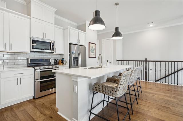 332 Adams Street Georgetown, TX 78628 - Photo 10 of 37 Modern kitchen with an inviting island and elegant hardwood flooring perfect for entertaining.
