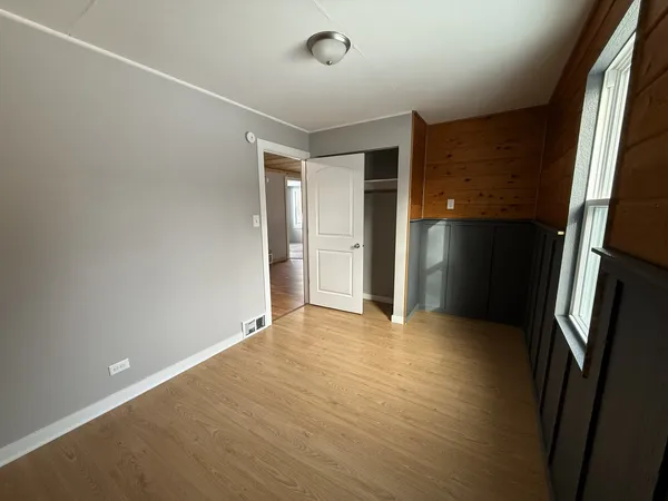 an empty room with closet and wooden floor