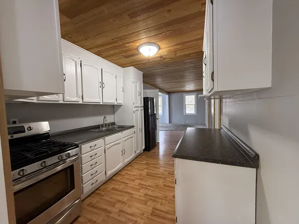a kitchen with granite countertop a stove and a refrigerator