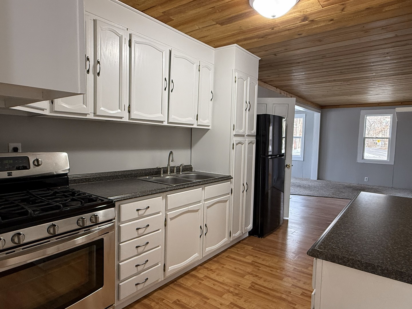 3717 State Line Road, Unit B Richmond, IL 60071 - Photo 6 of 20 a kitchen with granite countertop a stove and a refrigerator