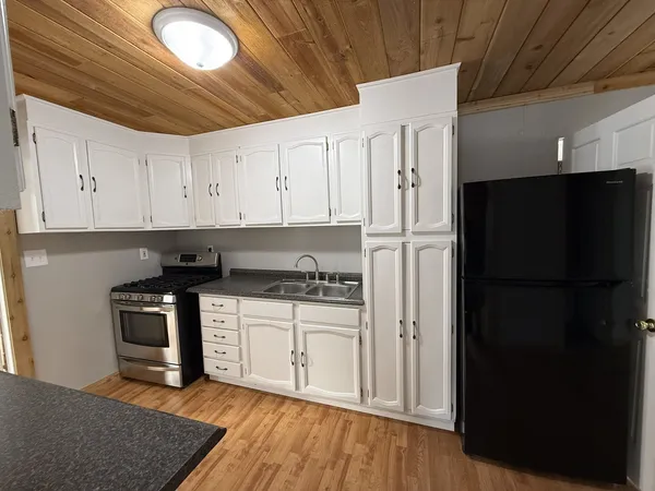 a kitchen with stainless steel appliances granite countertop a stove a refrigerator and a microwave