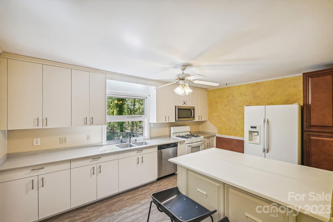 3710 Benjamin Street Richburg, SC 29729 - Photo 17 of 35 a kitchen with a refrigerator a sink dishwasher a stove and white cabinets with wooden floor