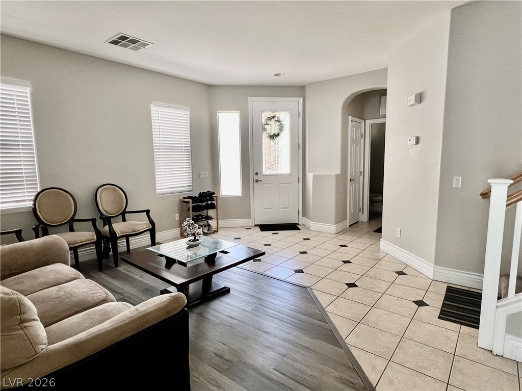 151 Short Ruff Way Las Vegas, NV 89148 - Photo 8 of 17 Welcoming entryway flows seamlessly into a comfortable living space with dual-style flooring and arched transitions.