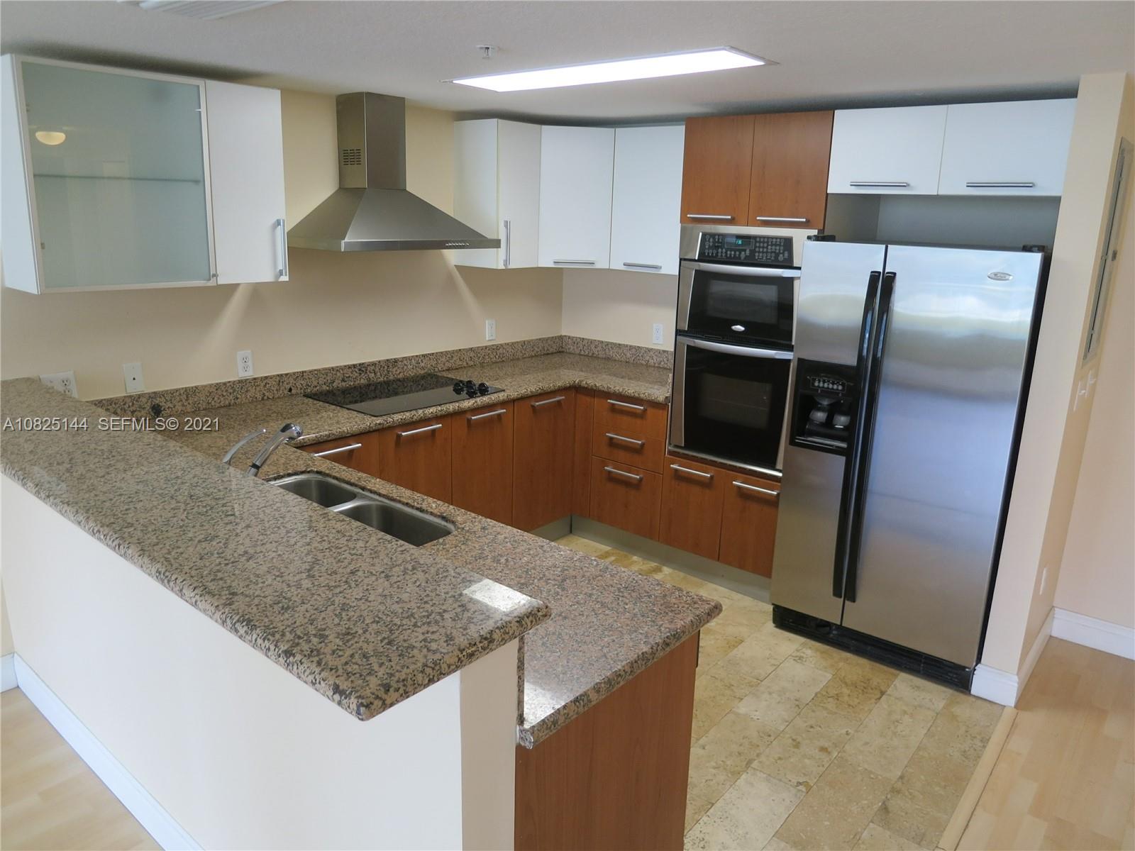 170 Southeast 14th Street, Unit 1507 Miami, FL 33131 - Photo 13 of 25 a kitchen with granite countertop a sink and stainless steel appliances