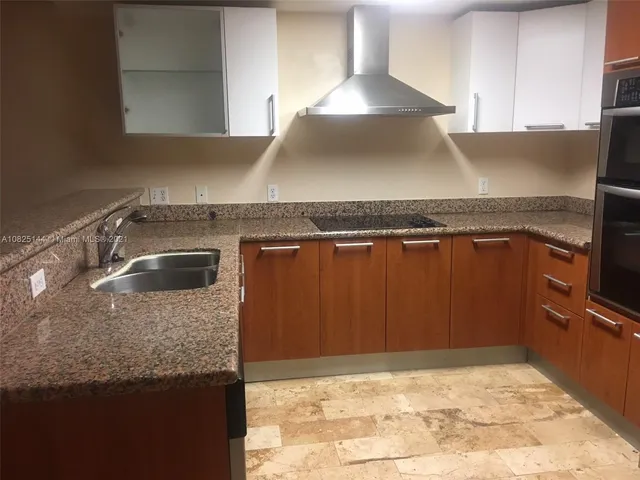 a kitchen with a sink a stove and cabinets