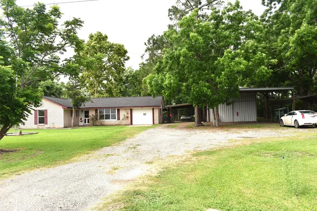 a front view of a house with a garden and trees