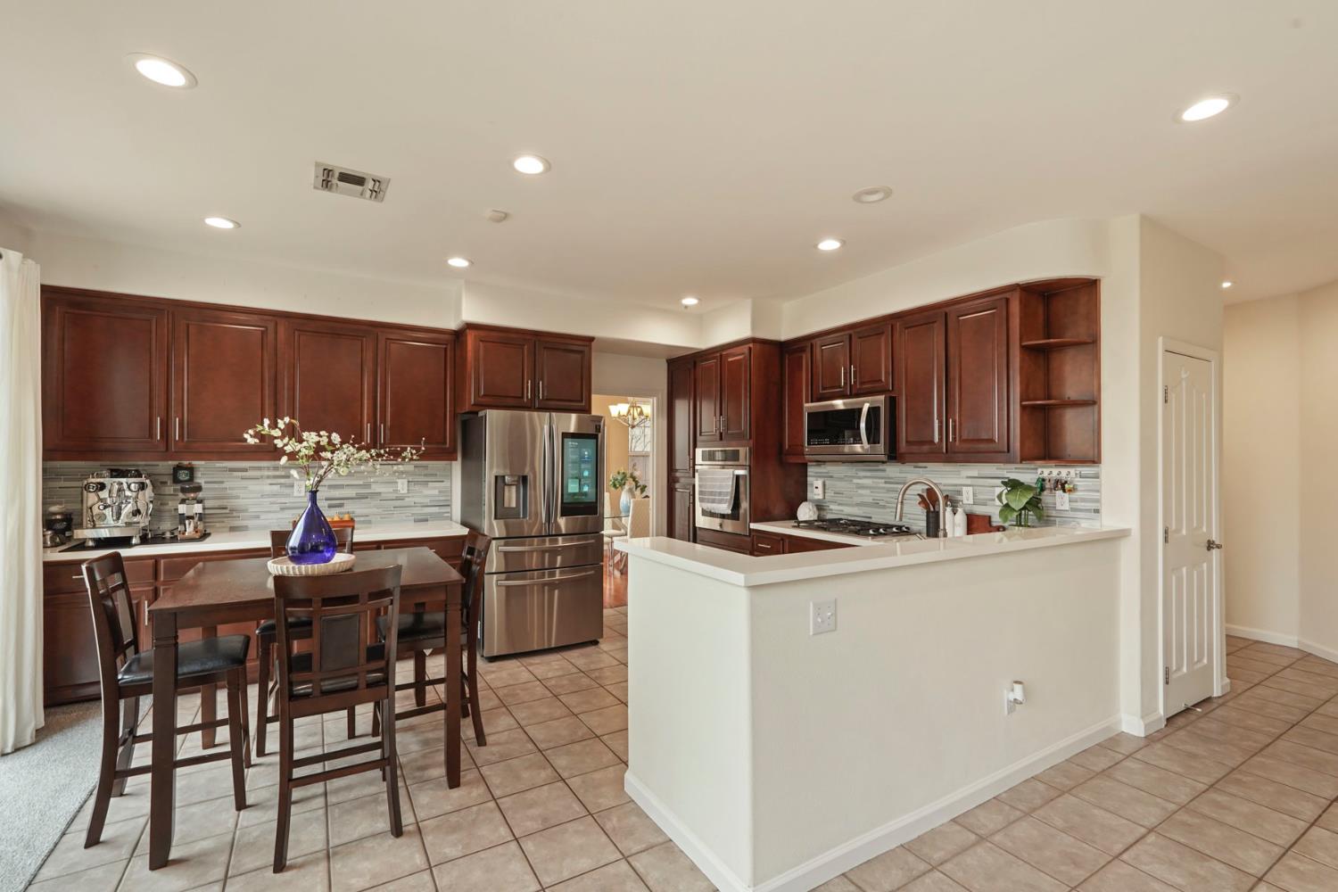 732 Pradera Way San Ramon, CA 94583 - Photo 11 of 45 a kitchen with stainless steel appliances kitchen island granite countertop a refrigerator and a stove top oven with white cabinets