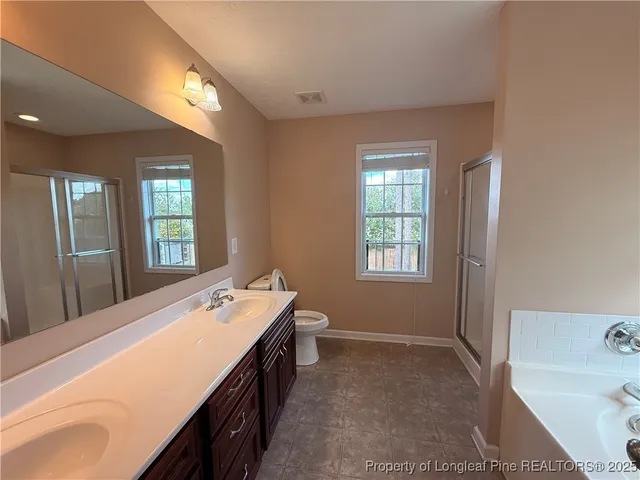 a bathroom with a tub shower vanity and a sink