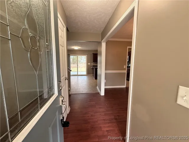 a view of empty room with wooden floor