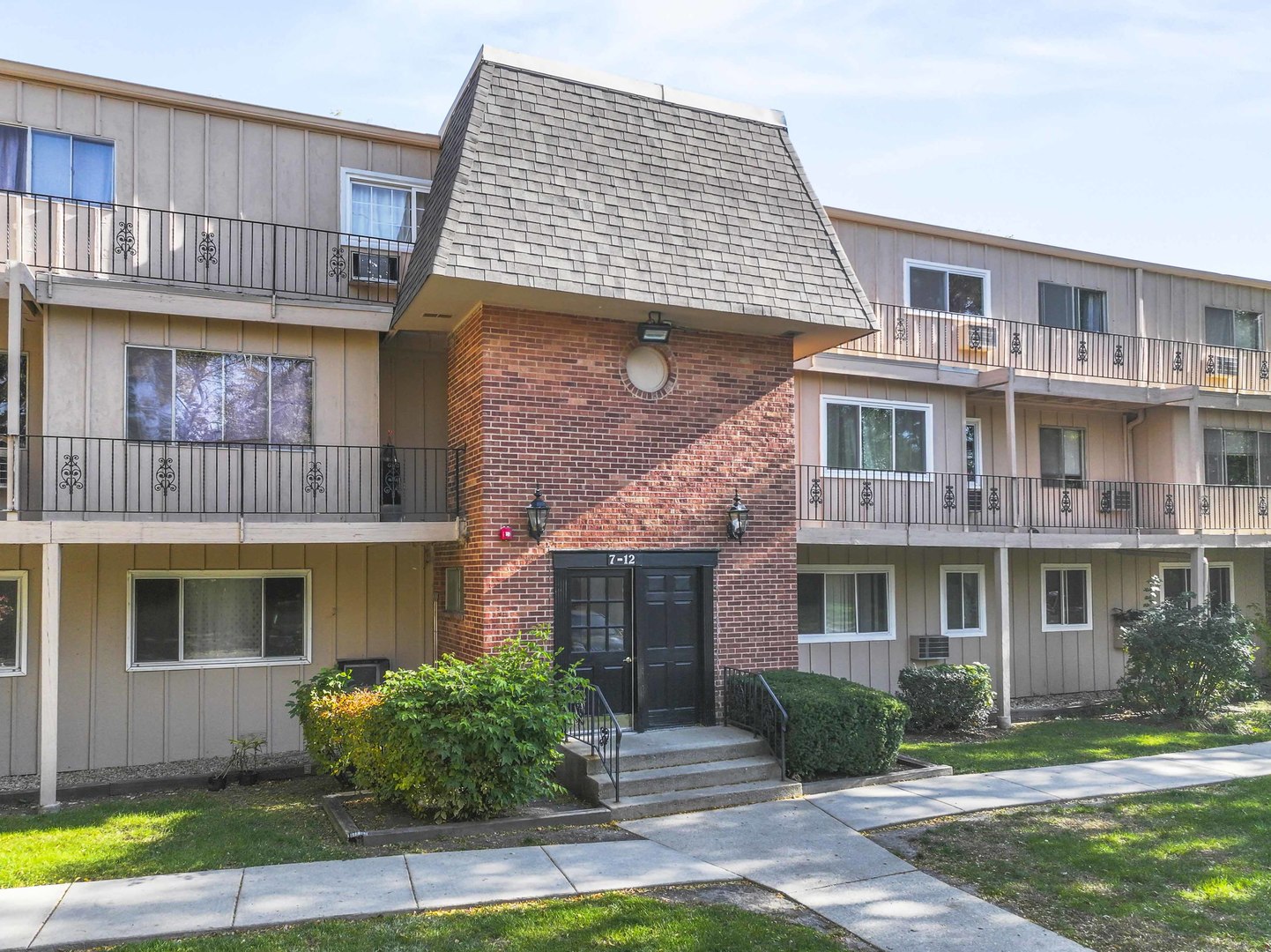 2504 West Algonquin Road, Unit 17 Rolling Meadows, IL 60008 - Photo 2 of 21 a front view of a brick house with a yard and large windows