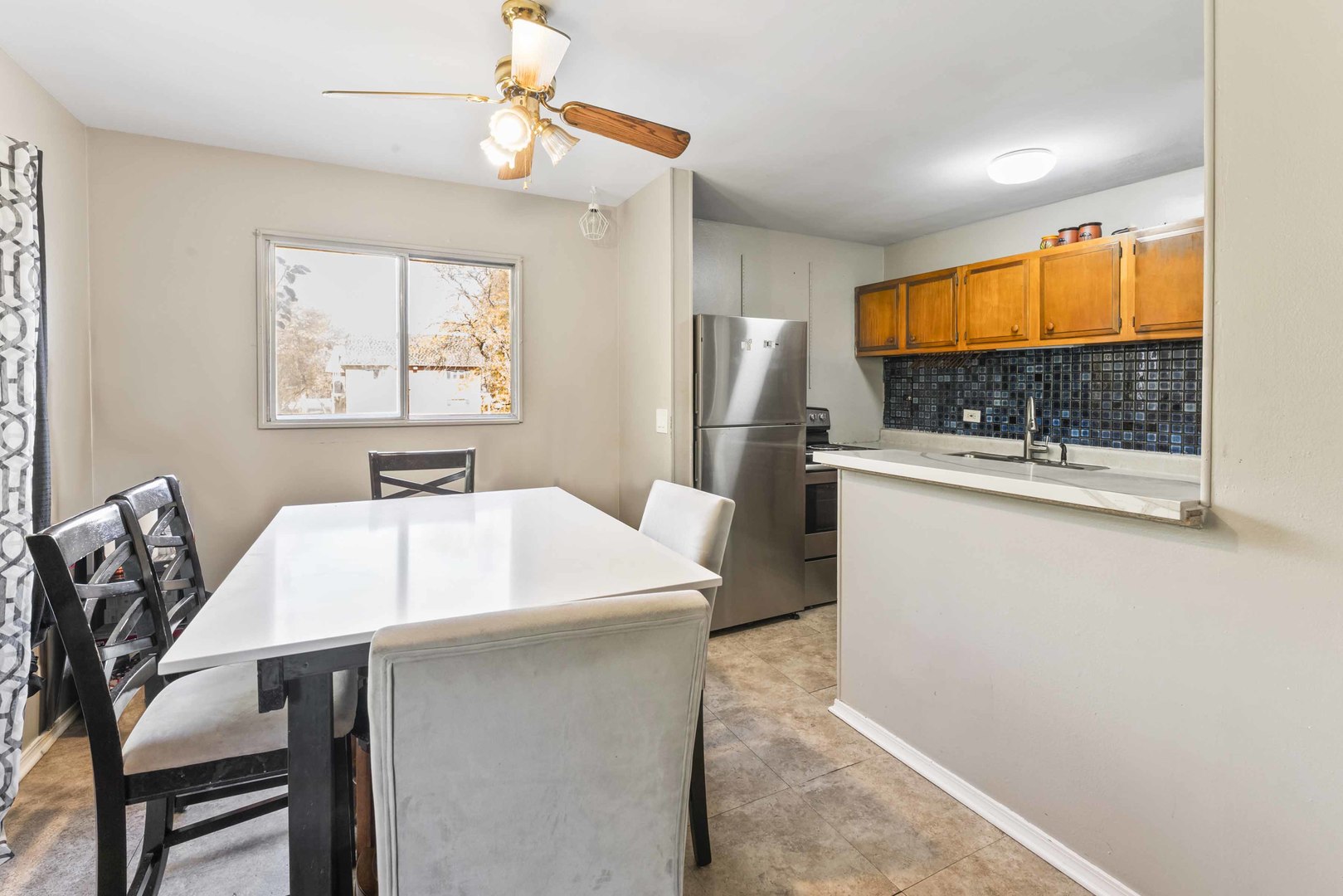 2504 West Algonquin Road, Unit 17 Rolling Meadows, IL 60008 - Photo 7 of 21 a kitchen with stainless steel appliances a stove a refrigerator a sink with a dining table and chair