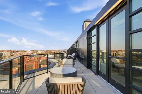 a view of a balcony with chairs and a floor to ceiling window