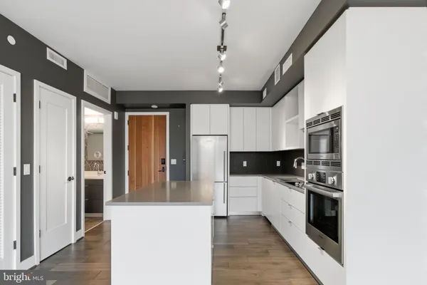 a kitchen with stainless steel appliances kitchen island granite countertop a refrigerator and a stove