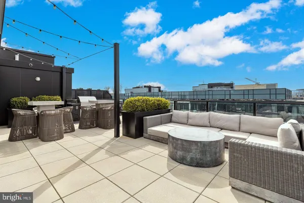 a view of a roof deck with couches and potted plants