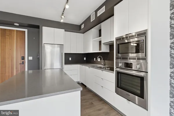 a kitchen with stainless steel appliances a stove microwave and refrigerator