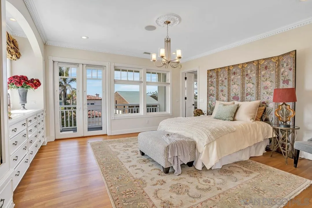 5735 Dolphin Place La Jolla, CA 92037 - Photo 25 of 75 a spacious bedroom with a large bed and a chandelier