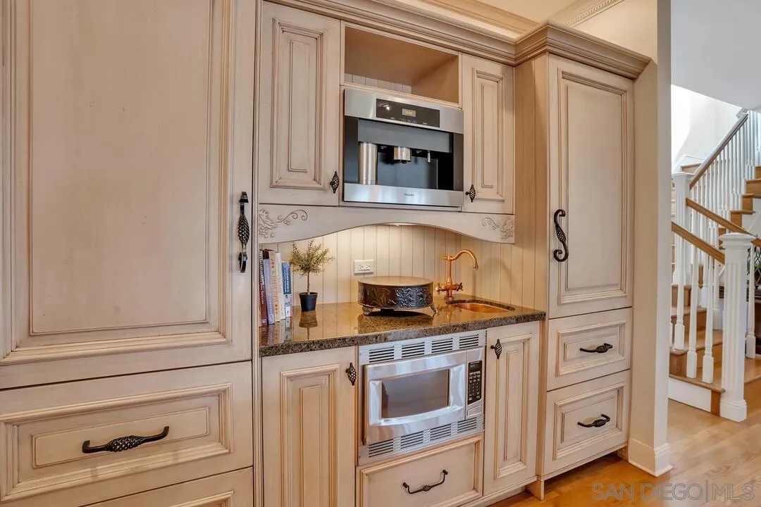 5735 Dolphin Place La Jolla, CA 92037 - Photo 7 of 75 a kitchen with stainless steel appliances granite countertop white cabinets and a stove