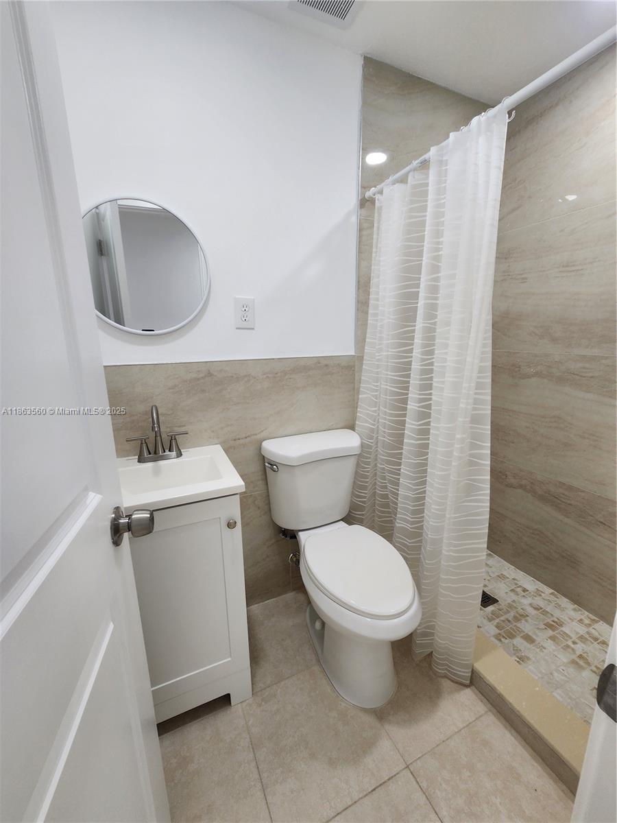 645 Northwest 7th Avenue, Unit STUDIO Homestead, FL 33030 - Photo 5 of 7 a white toilet sitting next to a bathroom sink