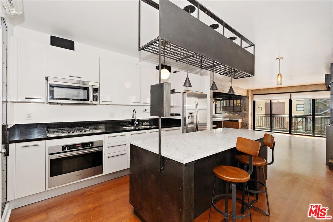416 South Spring Street, Unit 609 Los Angeles, CA 90013 - Photo 1 of 24 a kitchen with a stove a sink and a refrigerator