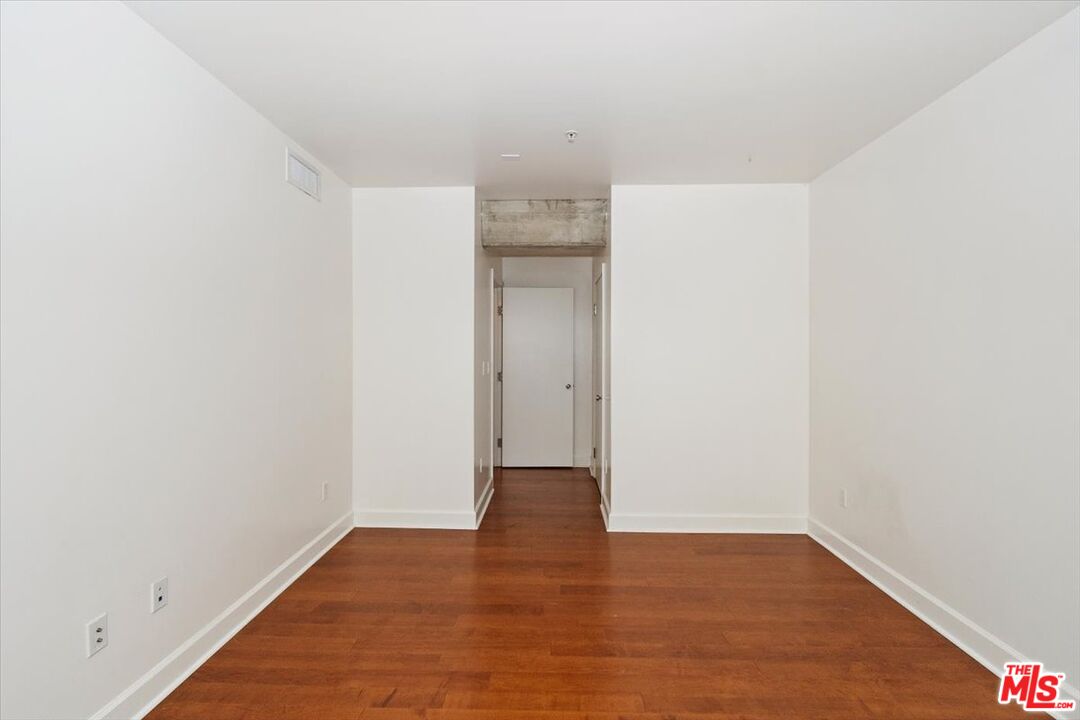 416 South Spring Street, Unit 609 Los Angeles, CA 90013 - Photo 14 of 24 a view of an empty room with wooden floor and a window