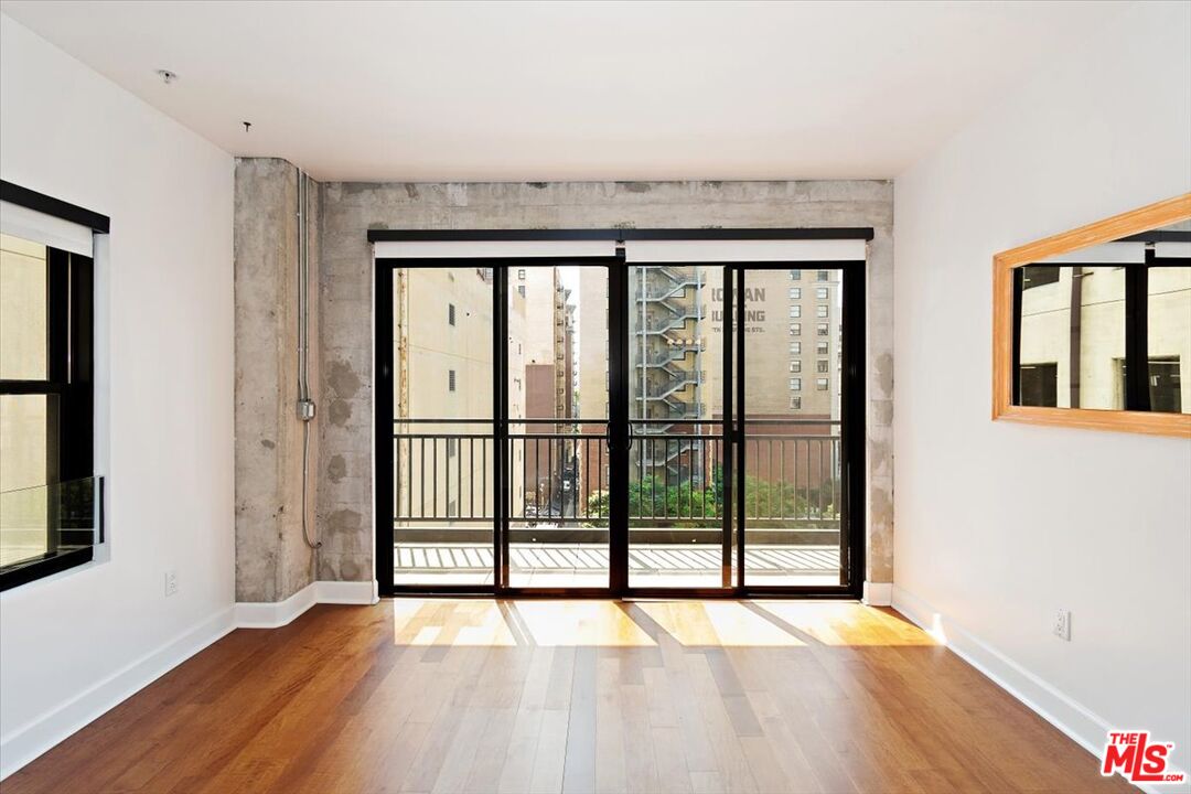 416 South Spring Street, Unit 609 Los Angeles, CA 90013 - Photo 18 of 24 a view of an empty room with wooden floor and a window