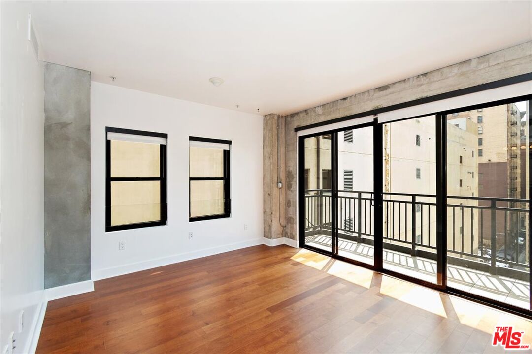 416 South Spring Street, Unit 609 Los Angeles, CA 90013 - Photo 20 of 24 a view of a big room with wooden floor and windows
