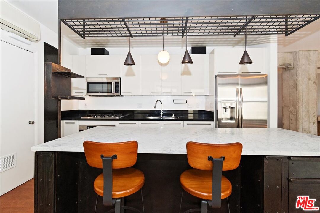 416 South Spring Street, Unit 609 Los Angeles, CA 90013 - Photo 2 of 24 a kitchen with stainless steel appliances a stove a sink and a refrigerator