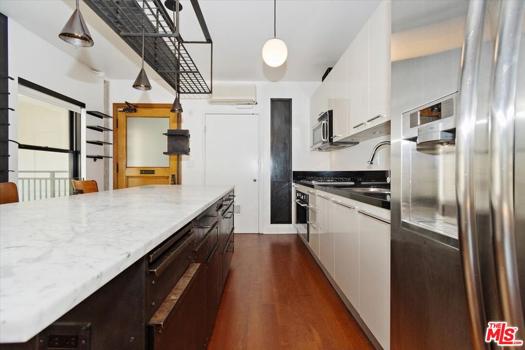 416 South Spring Street, Unit 609 Los Angeles, CA 90013 - Photo 4 of 24 a kitchen with stainless steel appliances sink stove refrigerator and cabinets
