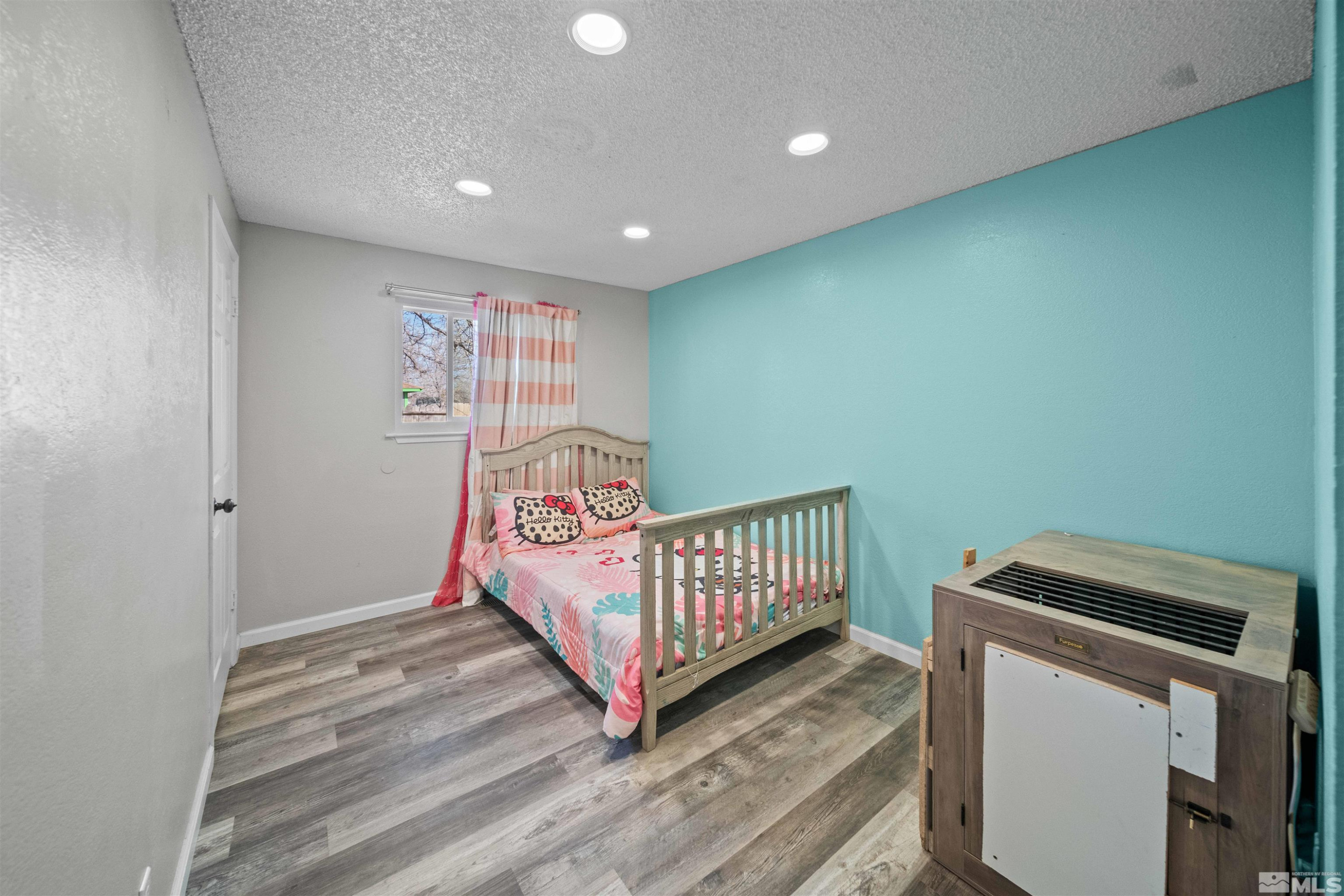 565 Spruce Drive Fernley, NV 89408 - Photo 12 of 19 a bedroom with a bed and wooden floor