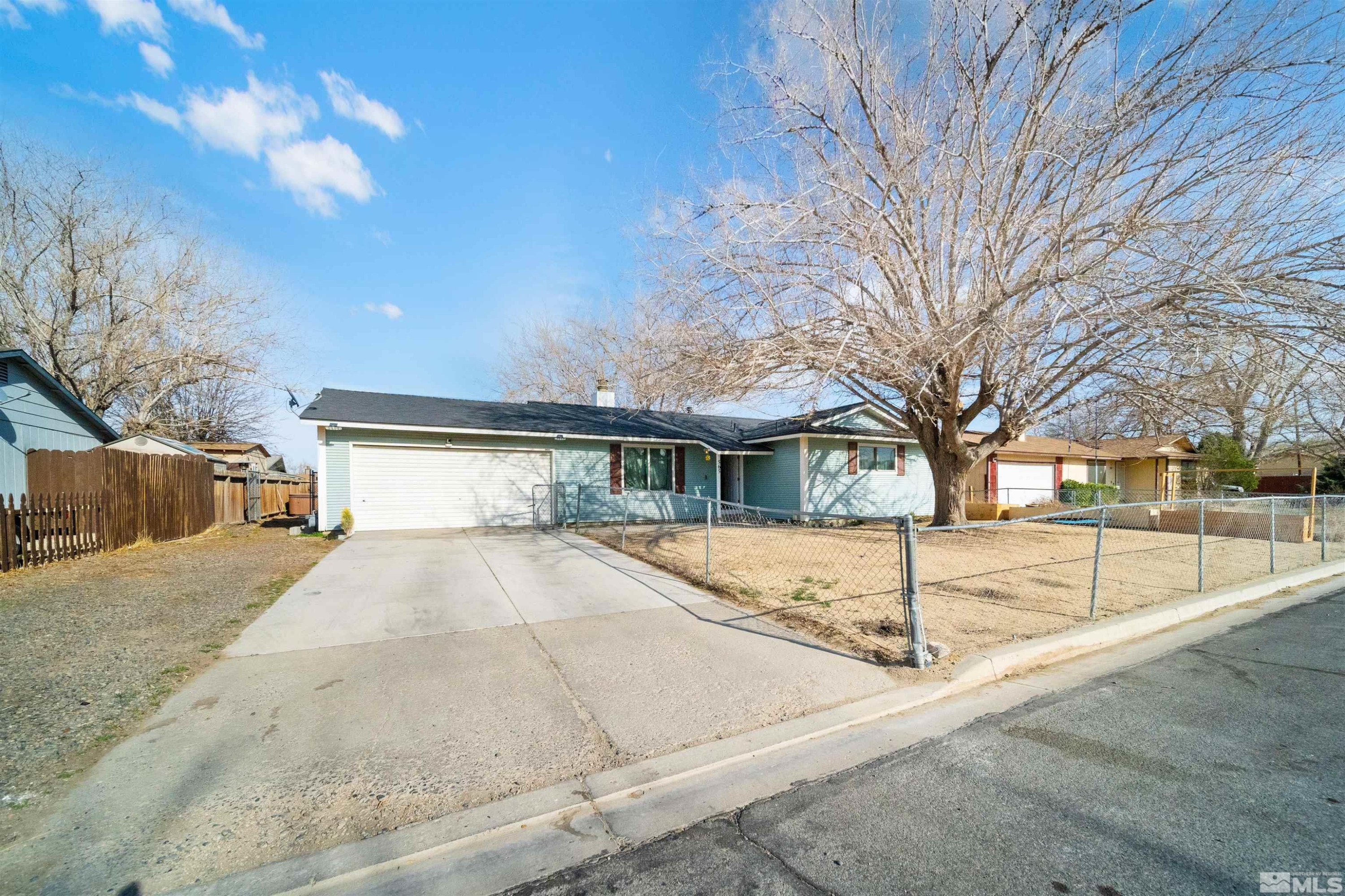 565 Spruce Drive Fernley, NV 89408 - Photo 2 of 19 a view of a white house with a large tree